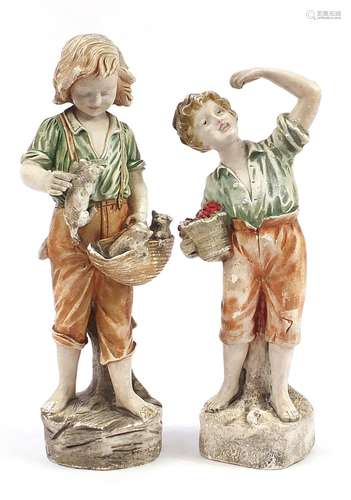 Two large plaster figures of a young boy with basket of frui...