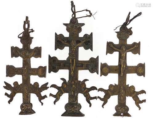 Three Spanish bronzed crucifixes, the largest 13cm high