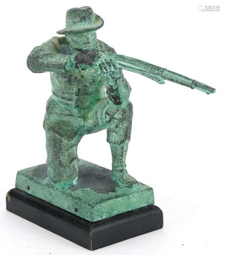 Verdigris patinated metal statue of a hunter holding a shotg...