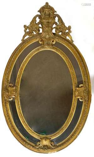 Grand miroir ovale Napoléon III en bois stuqué et doré. (Lég...