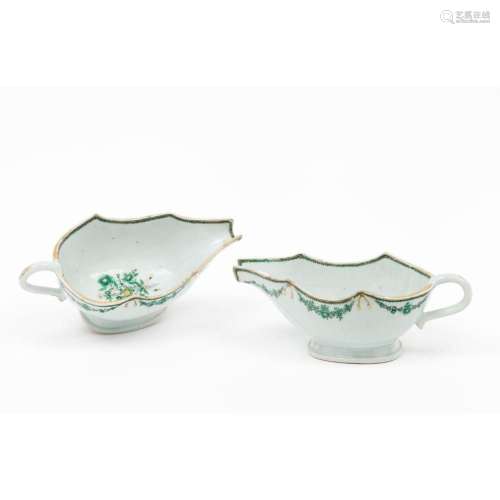 A pair of scalloped armorial sauce boats