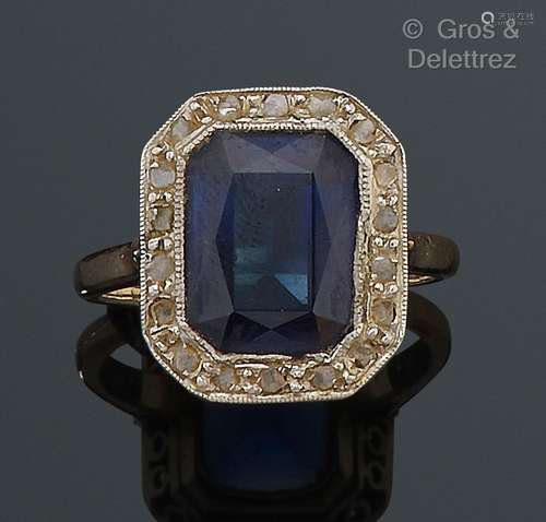 Bague en or jaune et gris, ornée d’une pierre bleue dans un ...