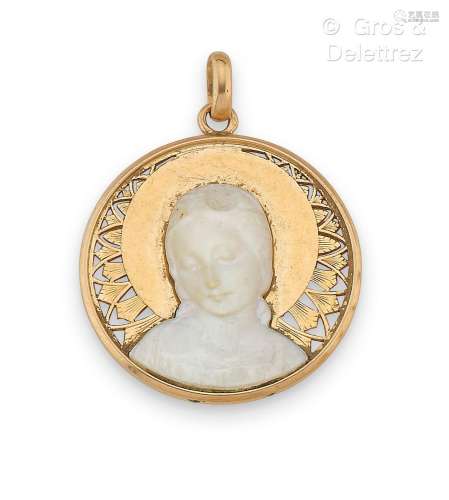 Médaille en or jaune ajouré, surmontée d’une plaque sculptée...