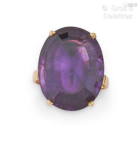 Bague en or jaune, ornée d’une pierre violette ovale. Tour d...