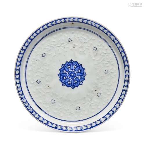 A SHALLOW IZNIK BLUE AND WHITE AND SLIP-PAINTED DISH OTTOMAN...