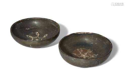 Two black glazed pottery bowls, each on a raised ring base, ...