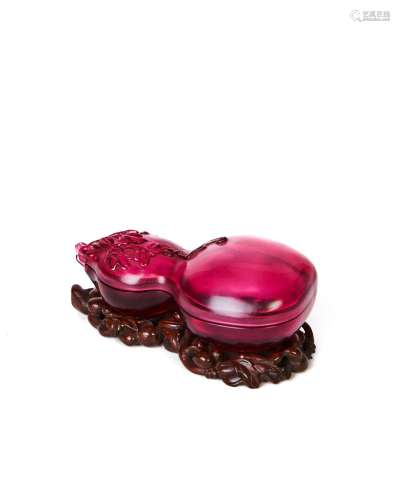 A RUBY GLASS DOUBLE GOURD SHAPED BOX ON A ROSE WOODEN STAND,...