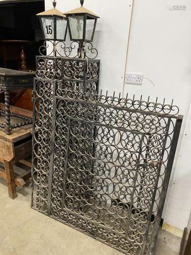 A pair of black painted wrought iron scroll work gates with ...