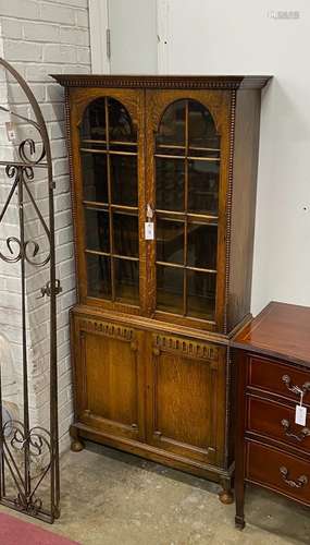 A 1920s glazed oak two door glazed cabinet, width 80cm, dept...