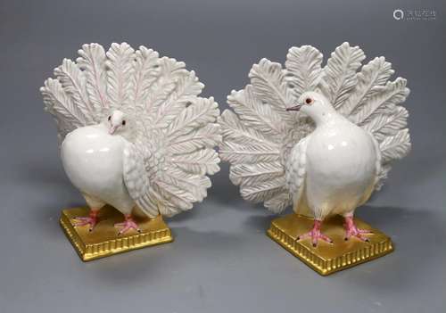 A pair of Nymphenberg porcelain figures of peacock tailed do...