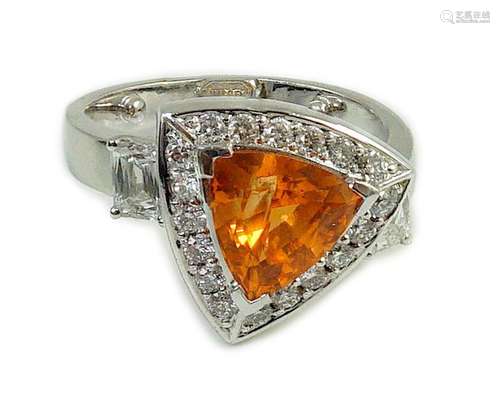 A modern platinum and single stone trilliant cut spessartite...