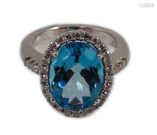 A modern 18k white gold, blue topaz and diamond oval cluster...