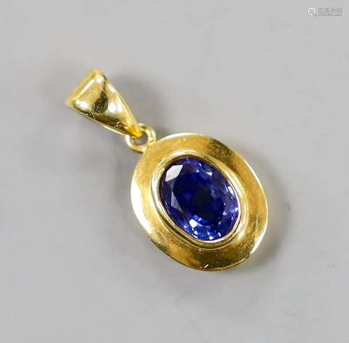 A modern 18k and oval cut sapphire set pendant, overall 22mm...