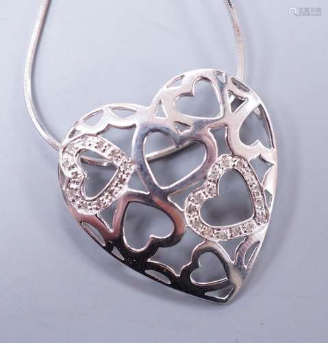 A modern 9k white metal and diamond chip set open work heart...