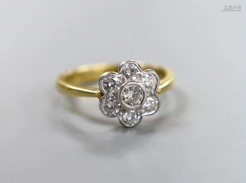 A modern 18ct gold and seven stone collet set diamond flower...