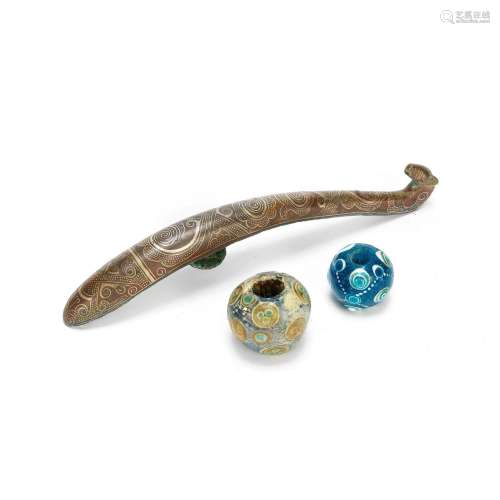 A GOLD AND SILVER INLAID BRONZE BELT HOOK AND TWO GLASS BEAD...