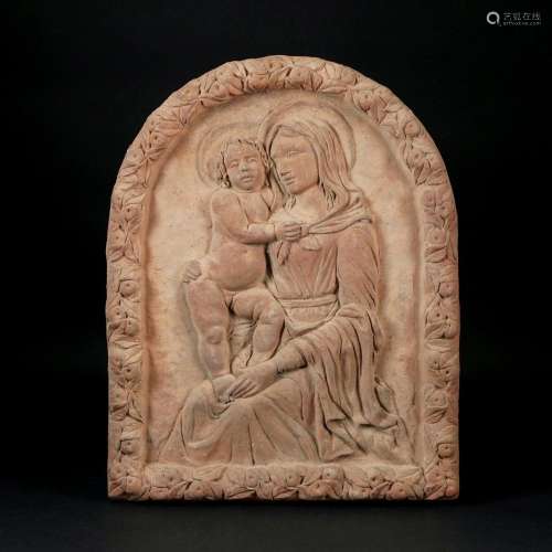 An arched terracotta low-relief with the Virgin and Child