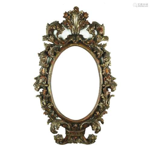 An oval carved silvered wood frame