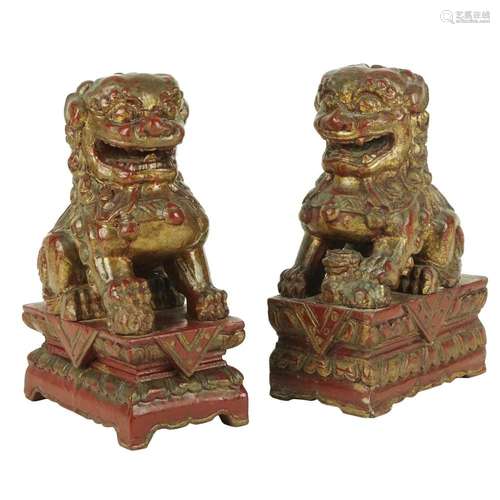 A pair of Chinese lacquered and gilt wood figures of a Foo d...