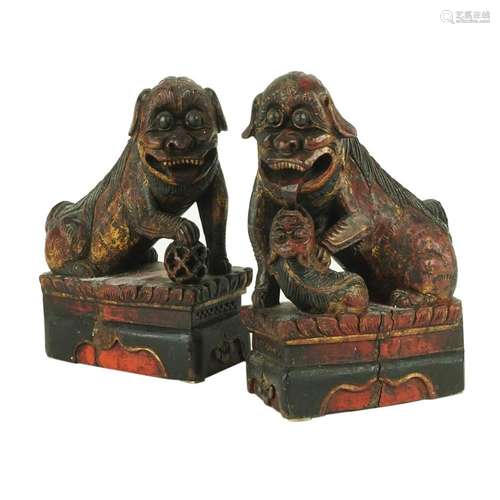 A pair of Chinese lacquered and gilt wood figures of a Foo d...