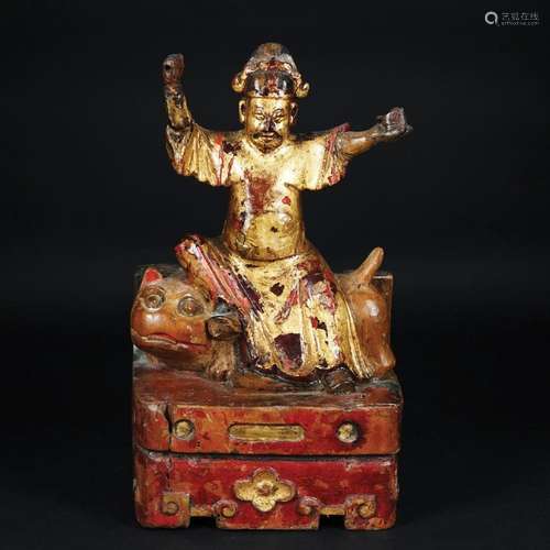 A Chinese lacquered and gilt wood figure of a divinity on a ...