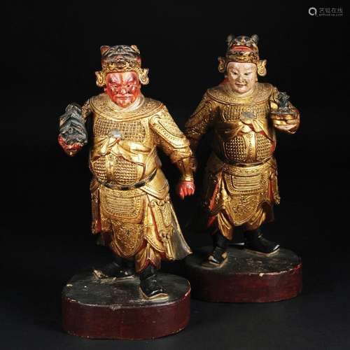 A pair of Chinese lacquered and gilt figures with zoomorphic...