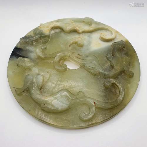 A carved Chinese green stone disc, 15 cm diameter