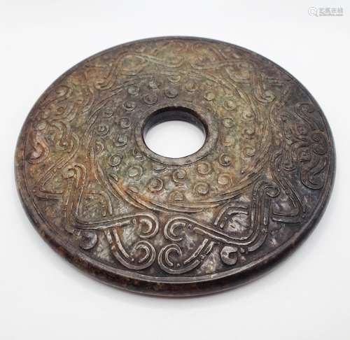 A Chinese carved stone disc, 12 cm diameter