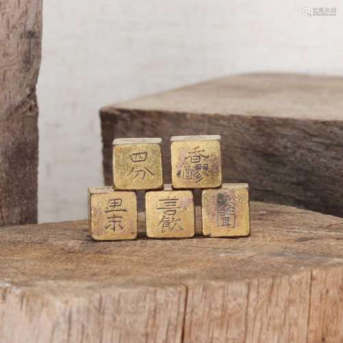 A collection of five gilt-bronze game dice,