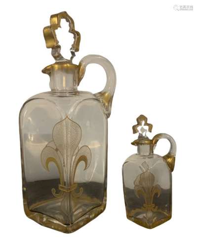 Deux CARAFES à décor de fleurs de lys, l'anse appliquée à ch...