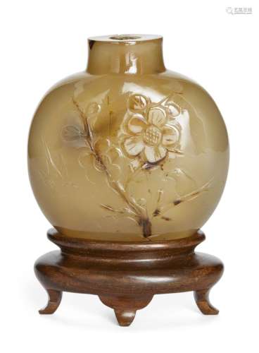 A Chinese agate snuff bottle, late 19th century, standing on...