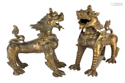 A pair of large Tibetan parcel gilt bronze mythical beasts, ...