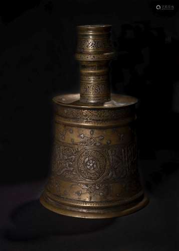 A HIGHLY IMPORTANT MAMLUK SILVER-INLAID BRASS CANDLESTICK, E...