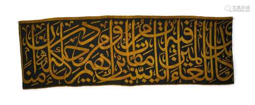 A BLACK AND GOLD SILK COTTON ISLAMIC CALLIGRAPHY PANEL, 20TH...