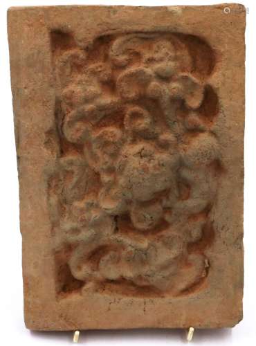 A Song Dynasty red clay tile, decorated in relief with a sty...