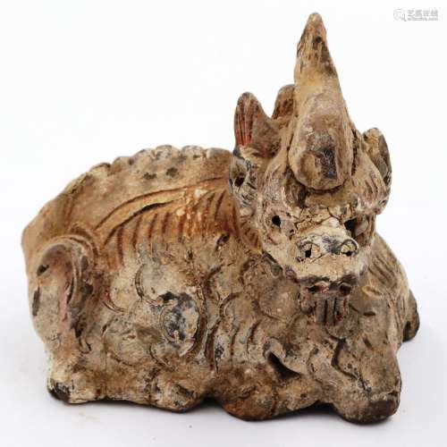 A Ming Dynasty zoomorphic clay recumbent dragon ornament, st...