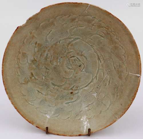 A celadon glazed porcelain bowl having incised decoration to...