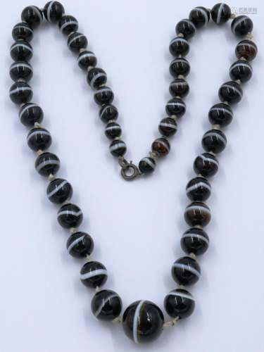 A single strand of graduated and polished brown manao agate ...