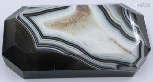 A polished manao banded and laced brown agate block with bev...