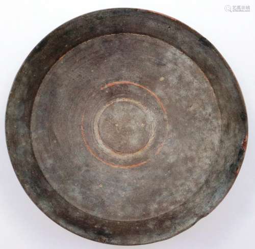 A Han Dynasty circular shallow bowl, coloured grey from terr...