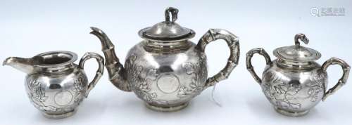 An export silver three-piece tea service, heavily embossed w...