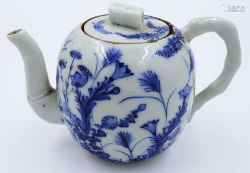An early 19th century porcelain teapot, decorated in blue ov...