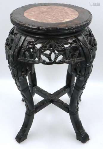A 19th century dark padouk wood vase stand, heavily carved w...