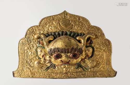 A gilt copper repoussé plaque depicting Kirtimukha. Tibet, 1...