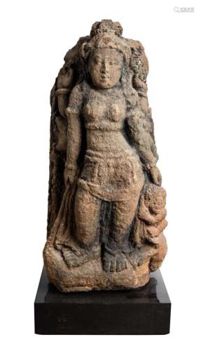 A JAVANESE VOLCANIC STONE FIGURE OF DURGA SLAYING THE BUFFAL...