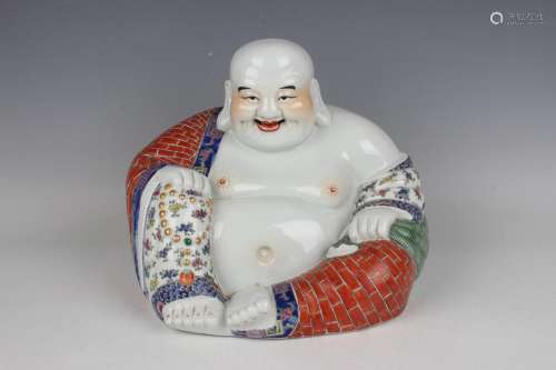 A Chinese famille rose porcelain figure of a seated smiling ...