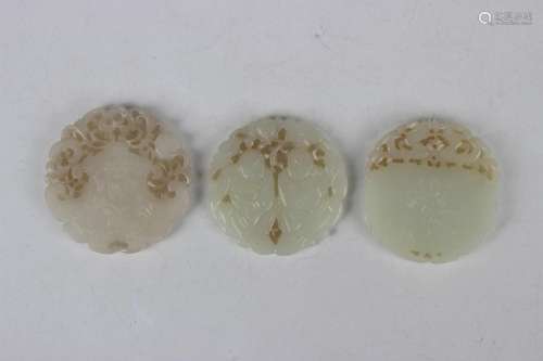 A group of three Chinese pale celadon jade circular plaque p...