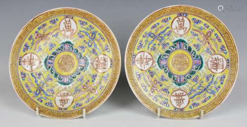 A pair of Chinese famille rose enamelled yellow ground porce...