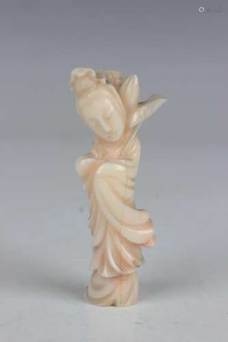 A Chinese carved white coral figure of a maiden holding a lo...