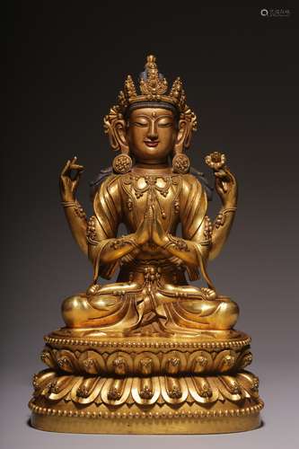 A sitting statue of Guanyin with four arms and bronze gilt i...